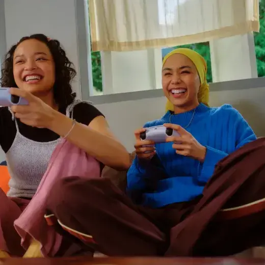 Two friends laughing while playing a video game