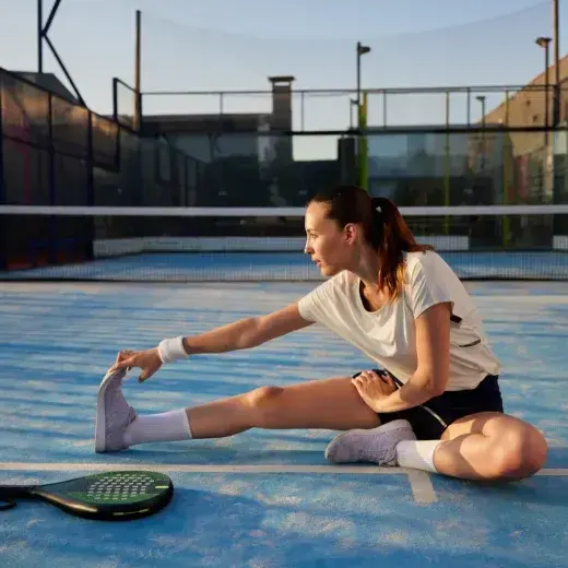Woman stretching on an outdoor court before a workout