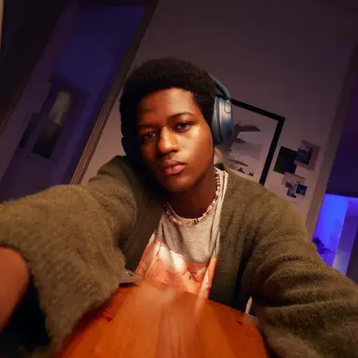 Man with headphones working at his desk in the evening