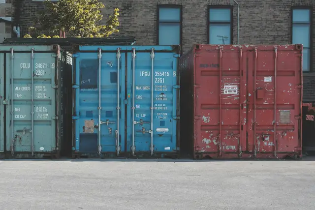 Blue steel storage container standing on an asphalt road