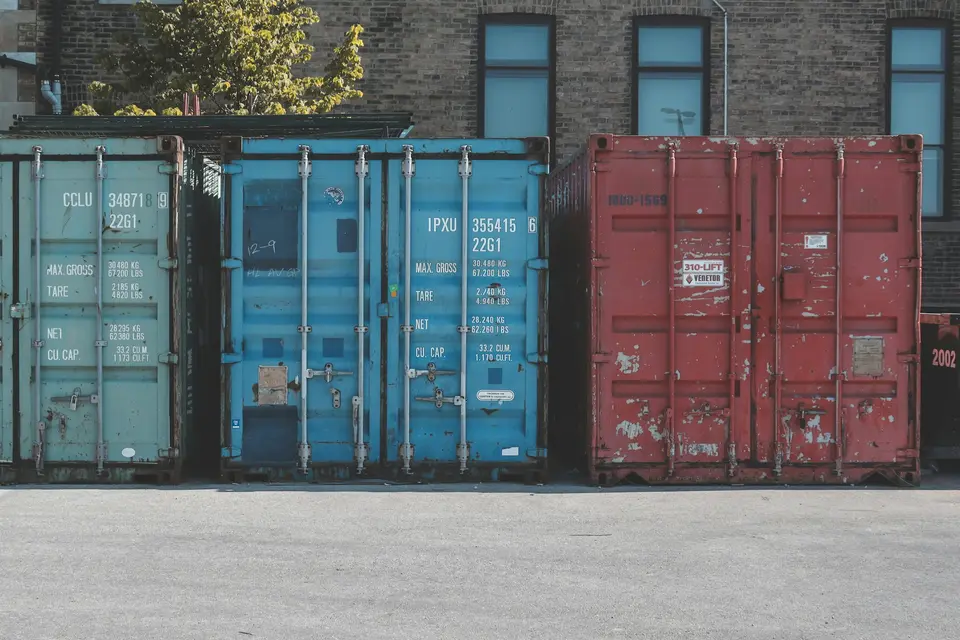 Blue steel storage container standing on an asphalt road