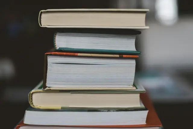 Stack of hardcover books on a dark table