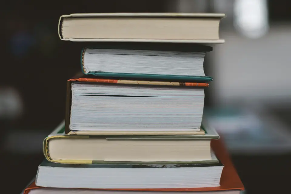 Stack of hardcover books on a dark table