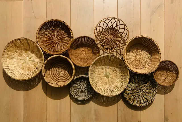 Handwoven round baskets arranged on a light wooden wall