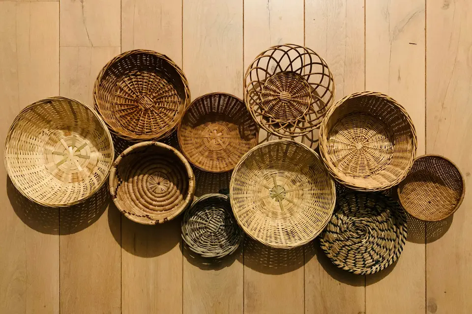 Handwoven round baskets arranged on a light wooden wall