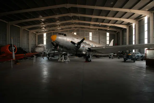 Vintage propeller airplanes on display inside a large museum hangar