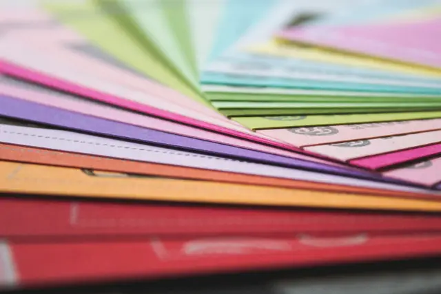 Fan of colored paper sheets in red, orange, pink, purple and green