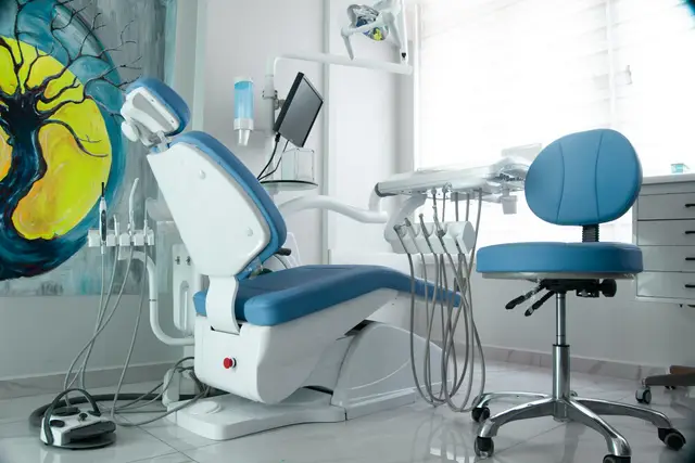 Dental treatment room with a blue patient chair and equipment