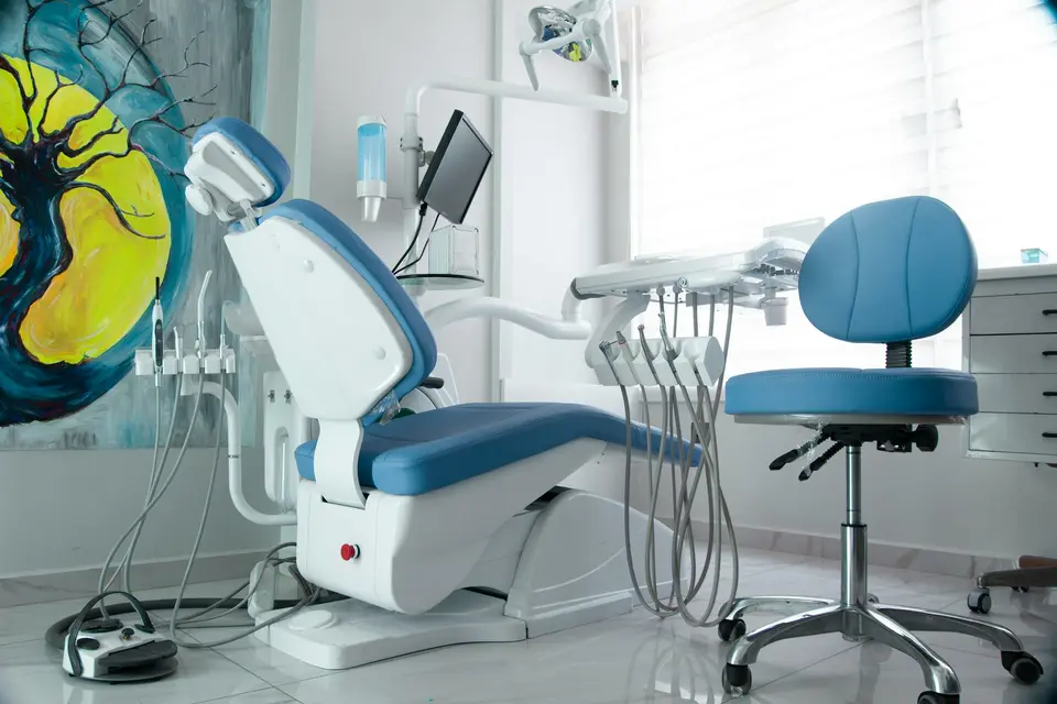 Dental treatment room with a blue patient chair and equipment