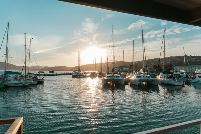 Boats moored in a calm marina at sunset