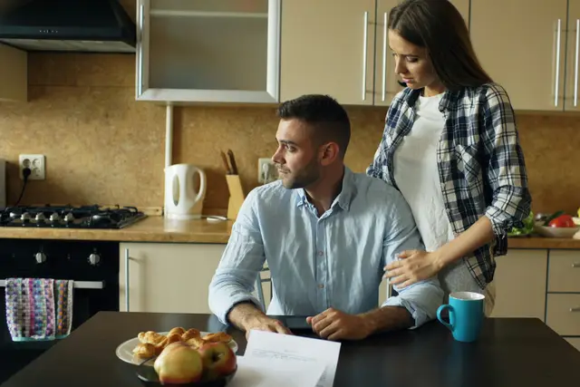 Couple at a kitchen table reviewing documents together over breakfast
