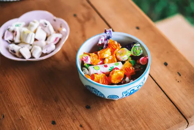 Bowls of colorful assorted candies on a wooden table