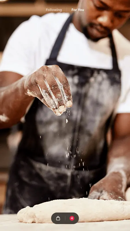 Baker dusting dough with flour, shown as a TikTok video ad with a shop button
