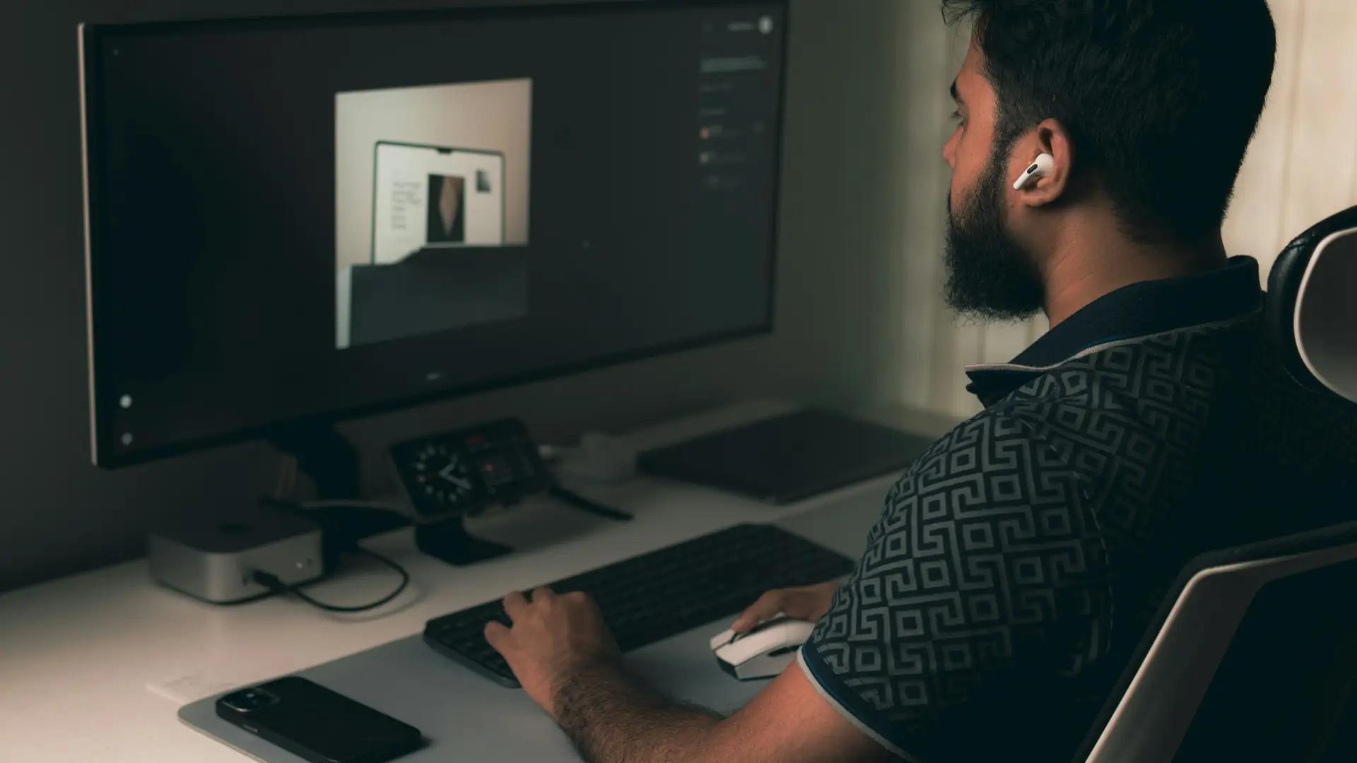 Web designer building a website at his desk in a dimly lit studio