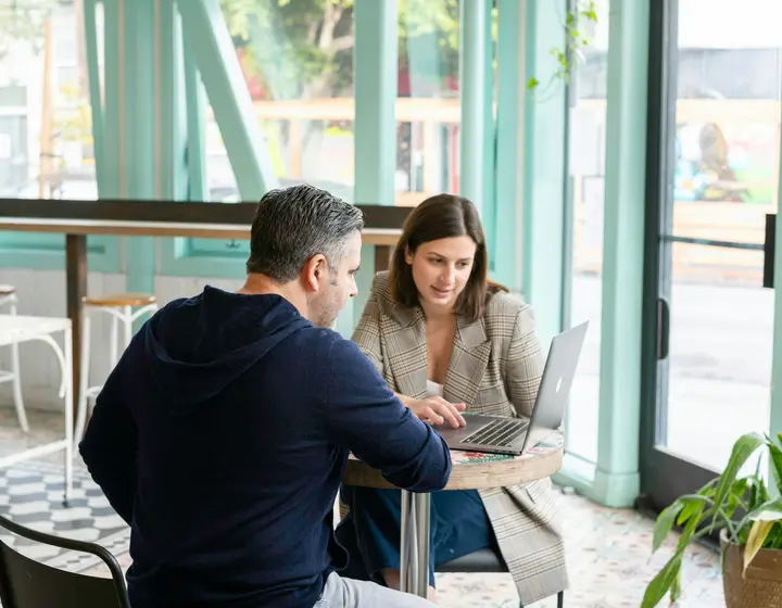 Business owner and strategist planning a website together at a cafe table