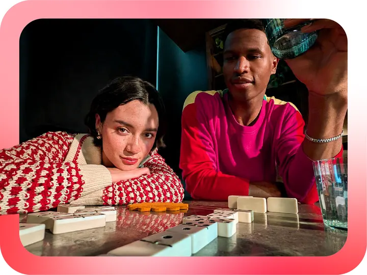 Two friends relaxing at home over a game of dominoes